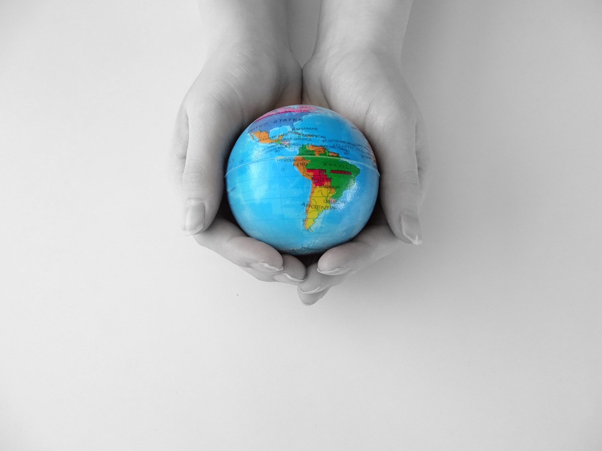 Hands holding a blue globe